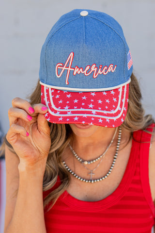 Person wearing a denim cap with 'America' and an American flag design.