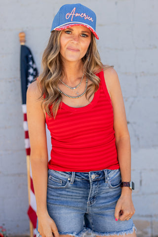 Person wearing a denim cap with 'America' and an American flag design.
