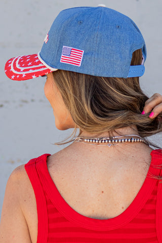 Person wearing a denim cap with 'America' and an American flag design.