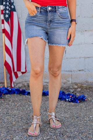 Person wearing denim shorts with an American flag in the background